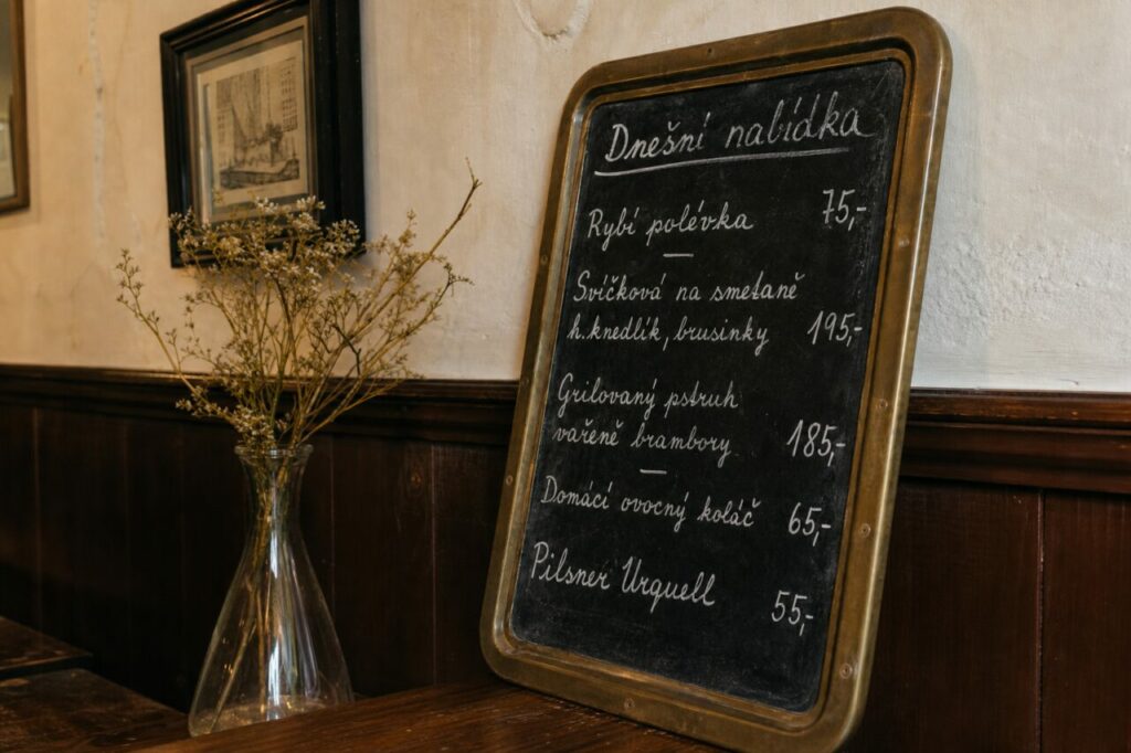 Quadro de menu inteiro sobre mesa junto de jarra alta