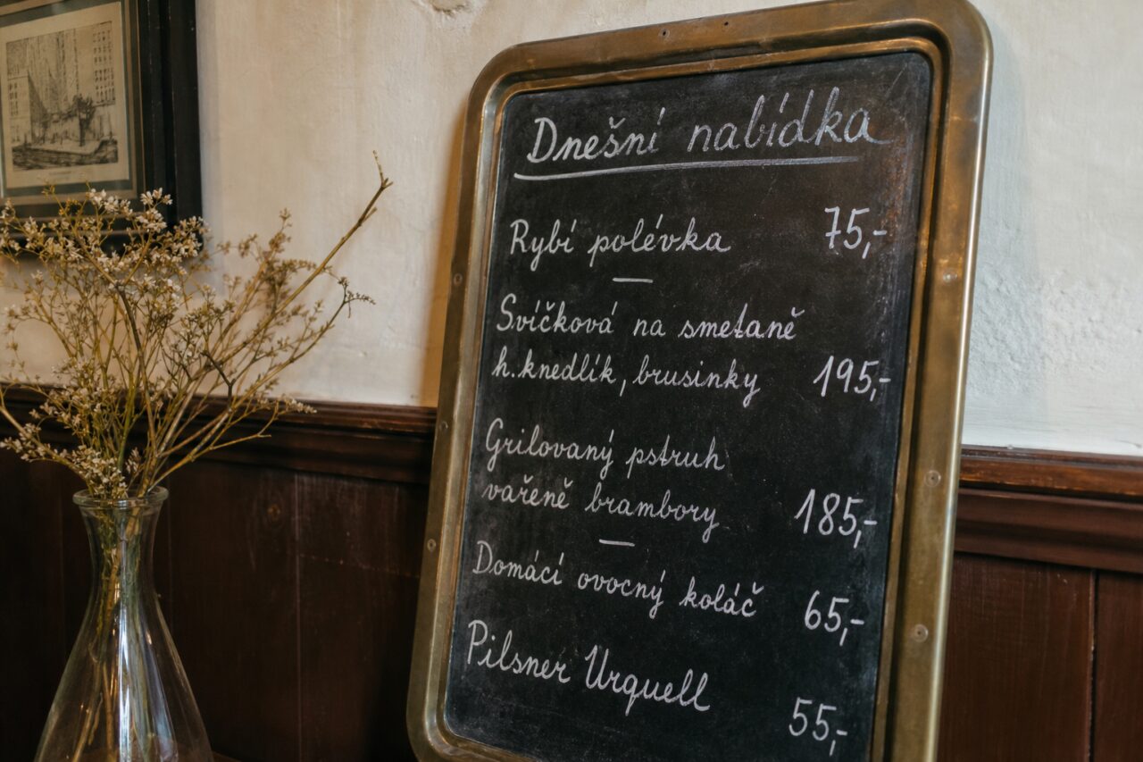 Handgeschreven menubord met vaas en lichte bloemen