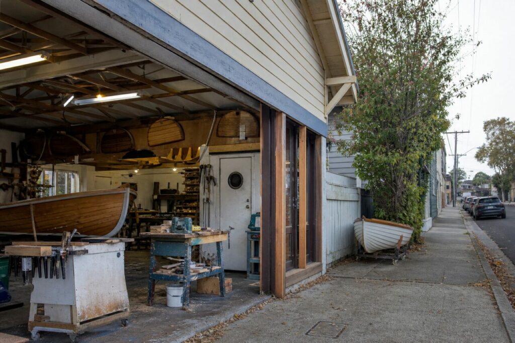 Atelier de construction navale en bois ouvert sur une rue de Sydney