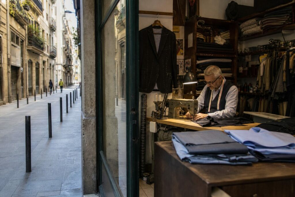 Atelier de tailleur ouvert sur une rue de Barcelone avec machine à coudre et tissus pliés