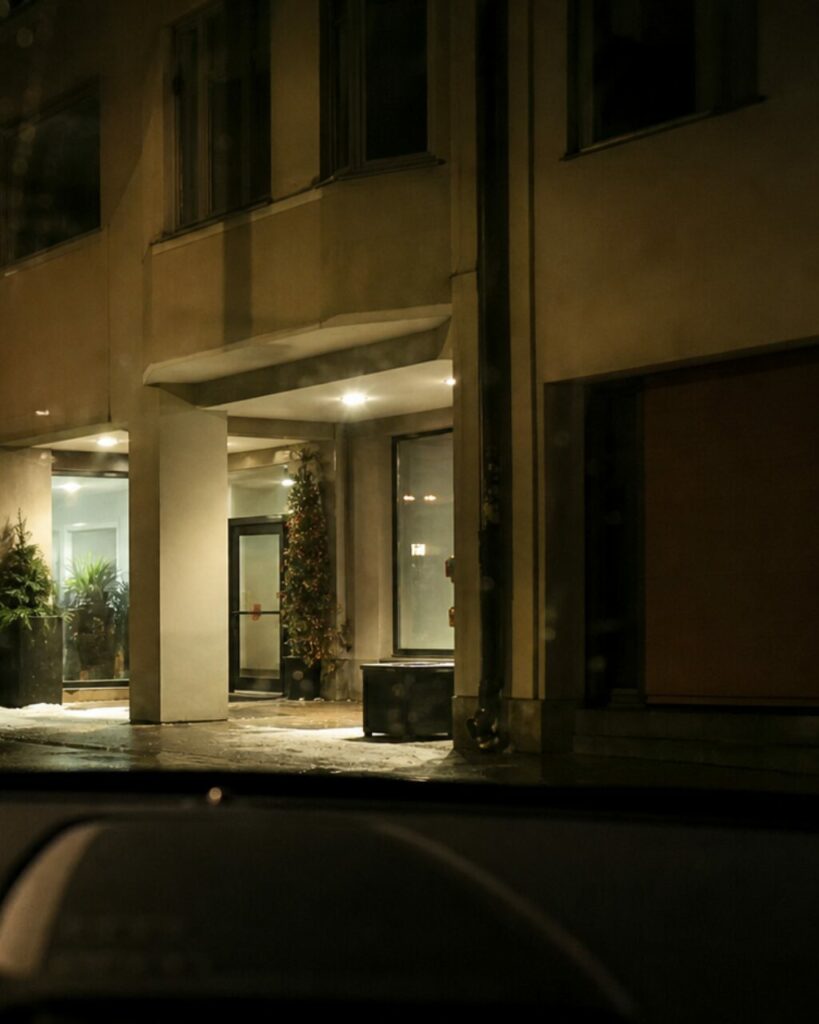 Auvent lumineux entre piliers et façade sombre