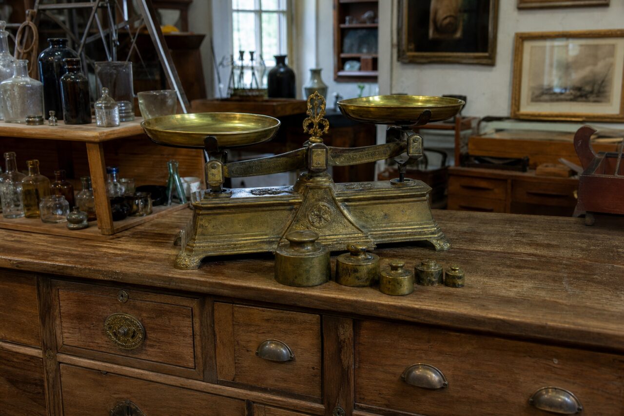 Brass balance and weights displayed at the centre of an antique shop