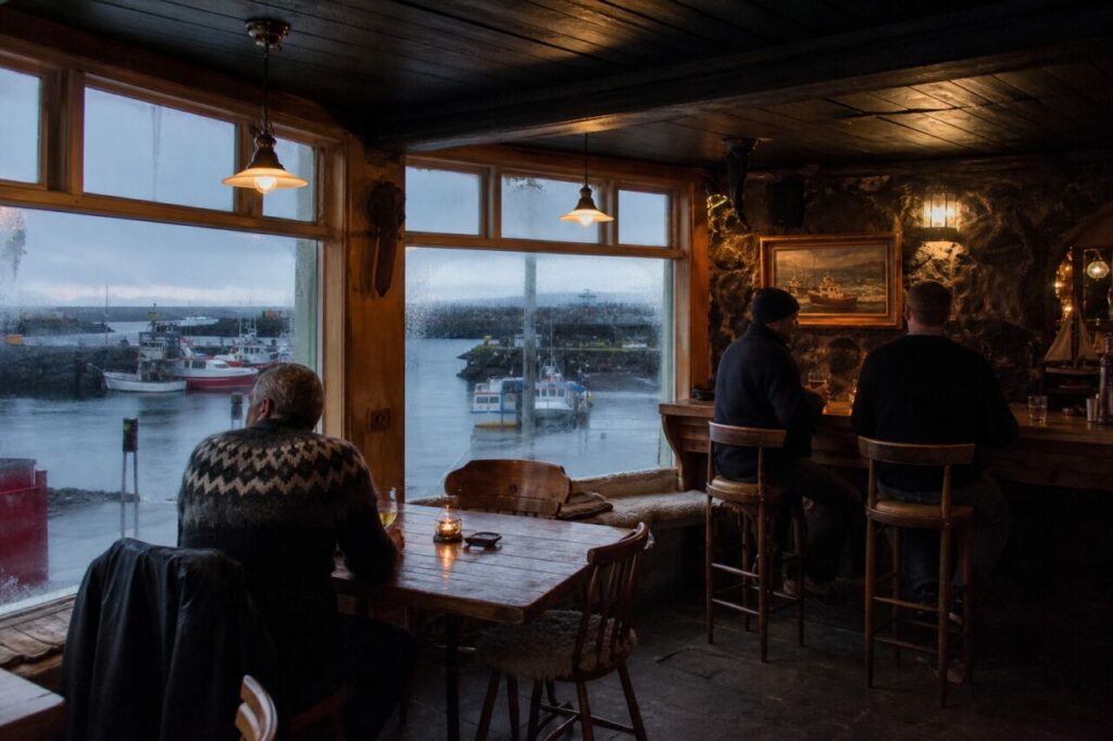 Rustikale Bar mit Blick auf Boote im kleinen Hafen