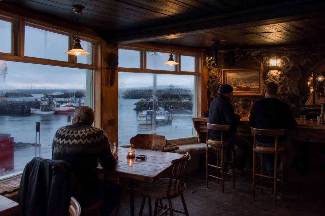 Rustikale Bar mit Blick auf Boote im kleinen Hafen