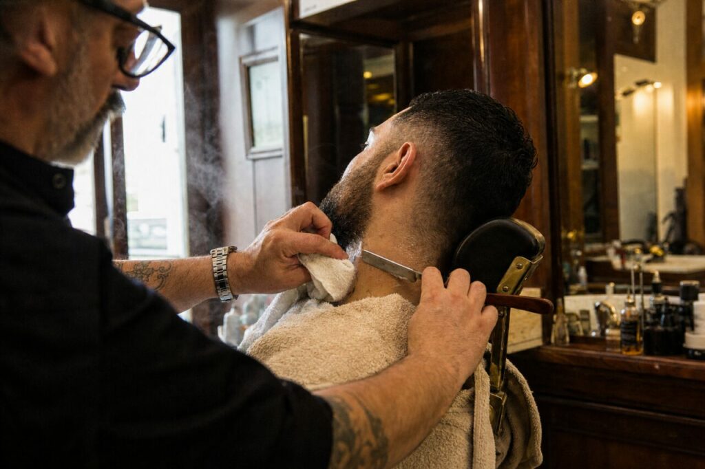 Barbier penché sur une nuque dans un salon boisé