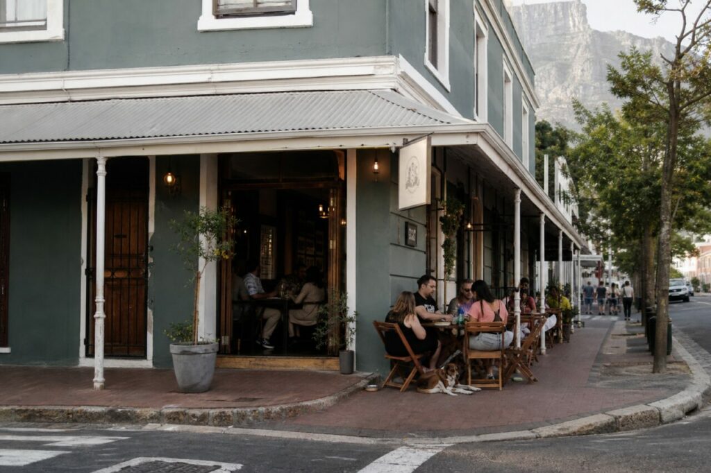 Bistrot d’angle vert-gris avec terrasse et relief rocheux