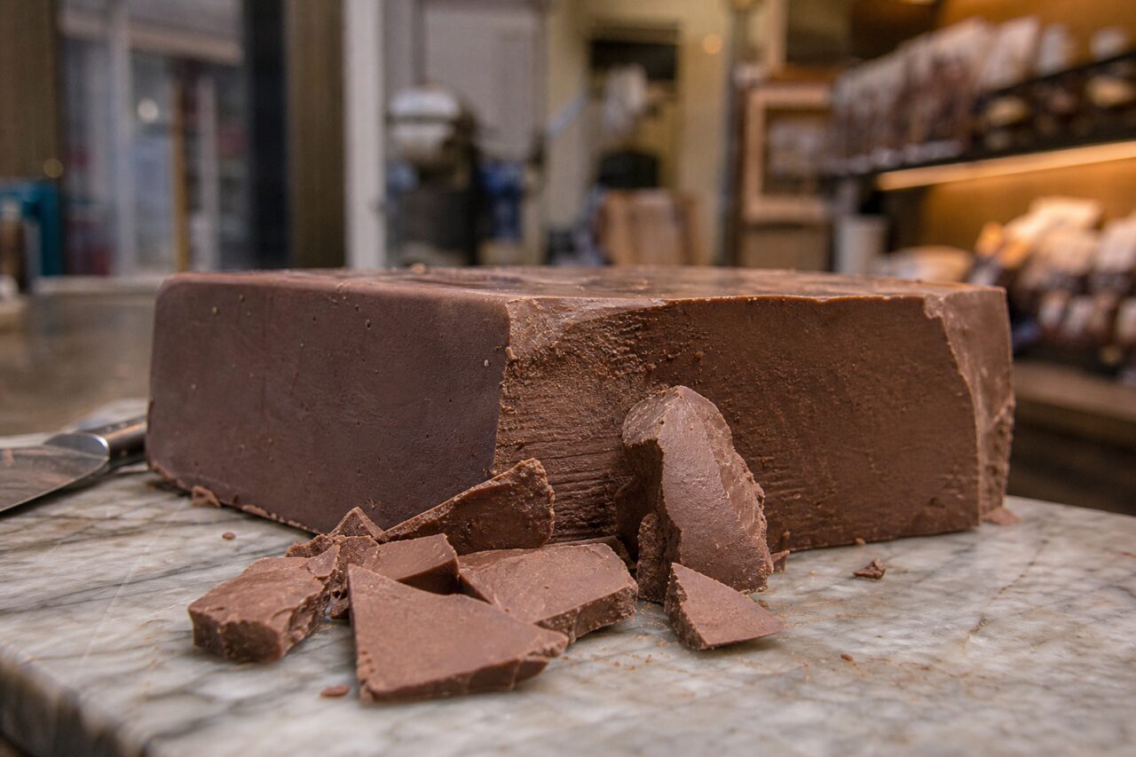 Gebroken blok melkchocolade op een marmeren plaat