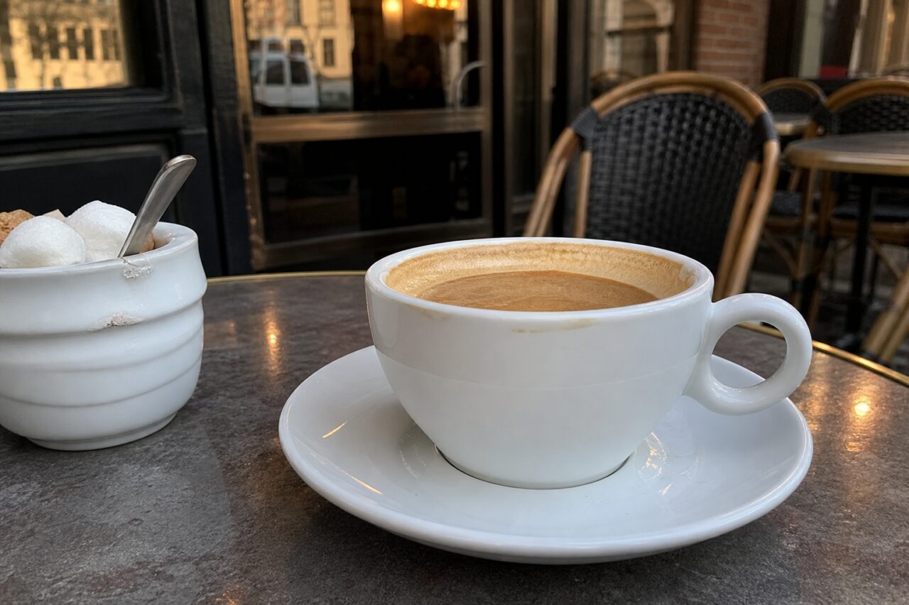 Coffee with milk on a dark table in the warm atmosphere of a café