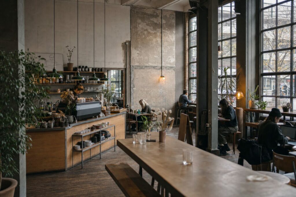 Helles Industriecafé rund um einen Holztresen