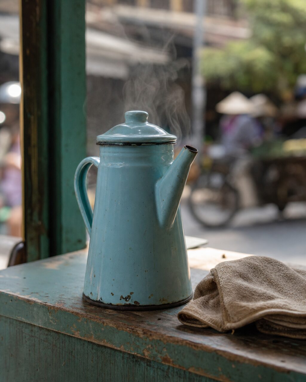 Steaming enamel coffee pot on a turquoise counter