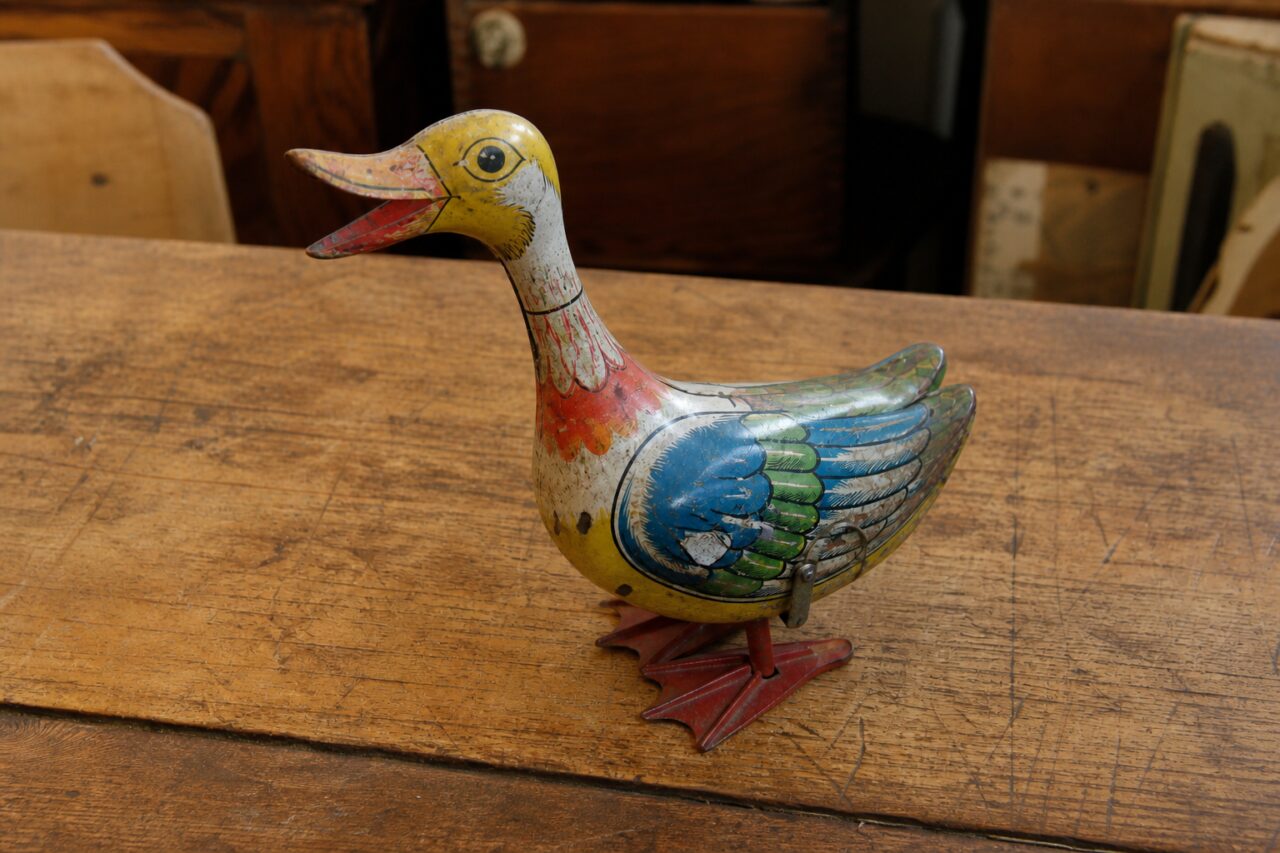 Slightly elevated view of a painted mechanical duck on a wooden table
