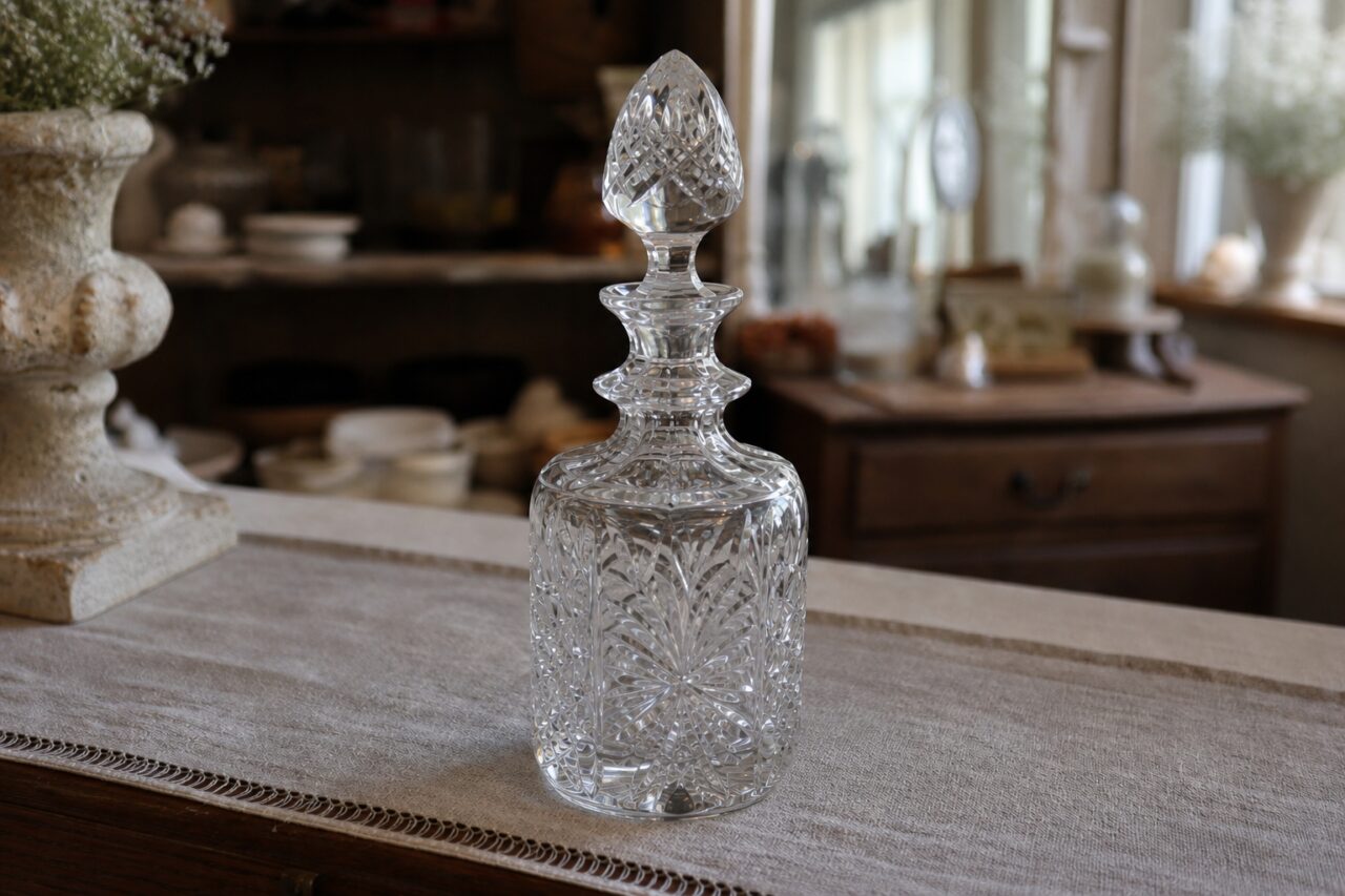 Cut-crystal decanter lit from the side with reflections and geometric cuts
