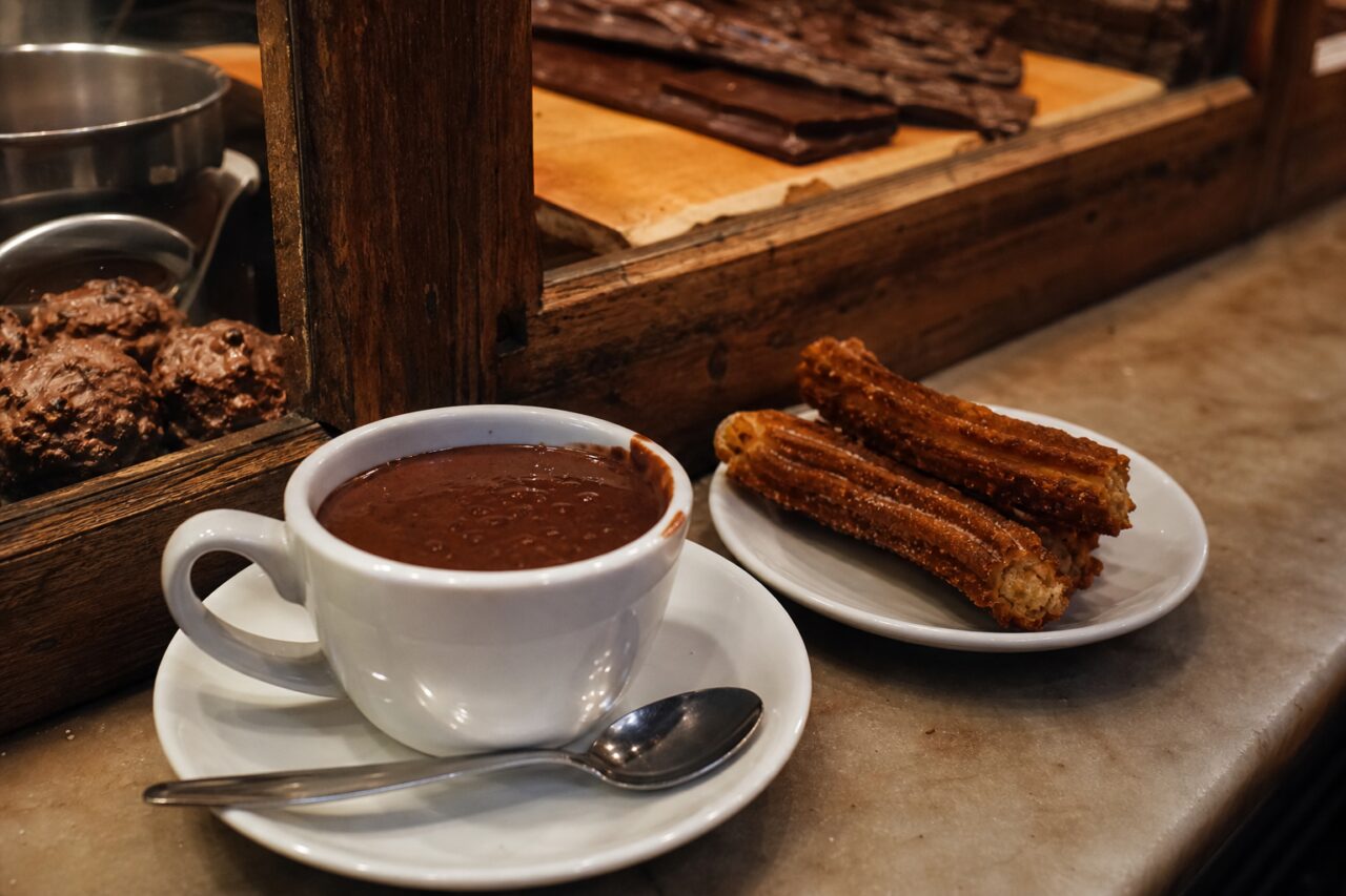Heiße Schokolade und Churros auf der Theke einer Chocolaterie
