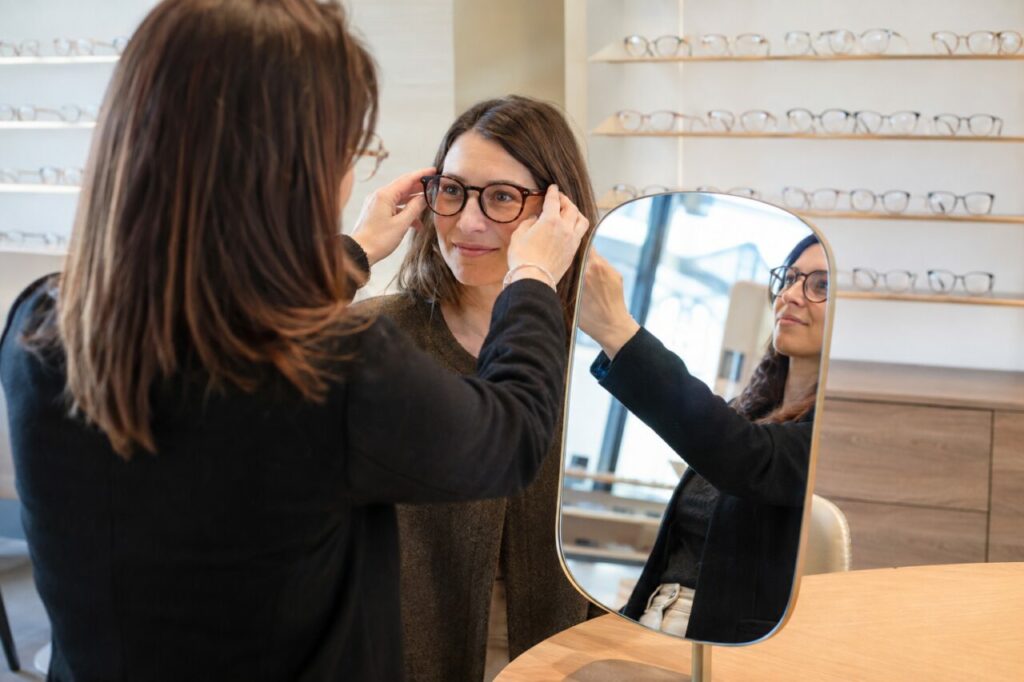 Choix de montures au comptoir — Lunettes et miroir dans la boutique