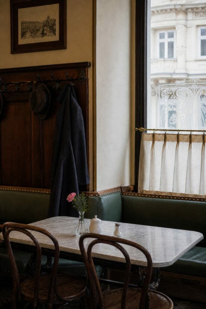 Corner bench with three chairs and a decorated window