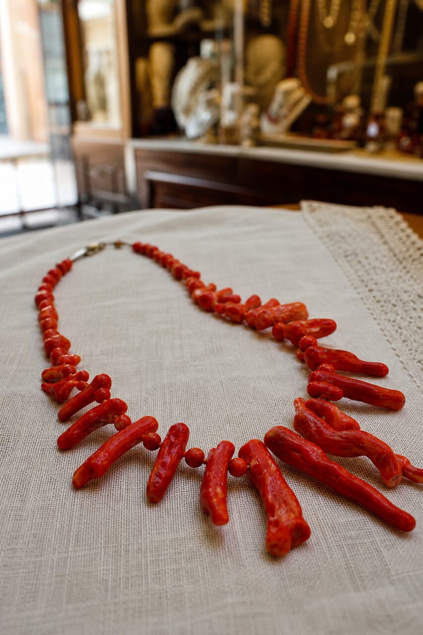 Collana rossa in verticale con forme lunghe in primo piano