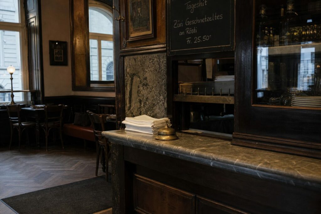 Comptoir à sonnette entre salle, tableau noir et vitrine