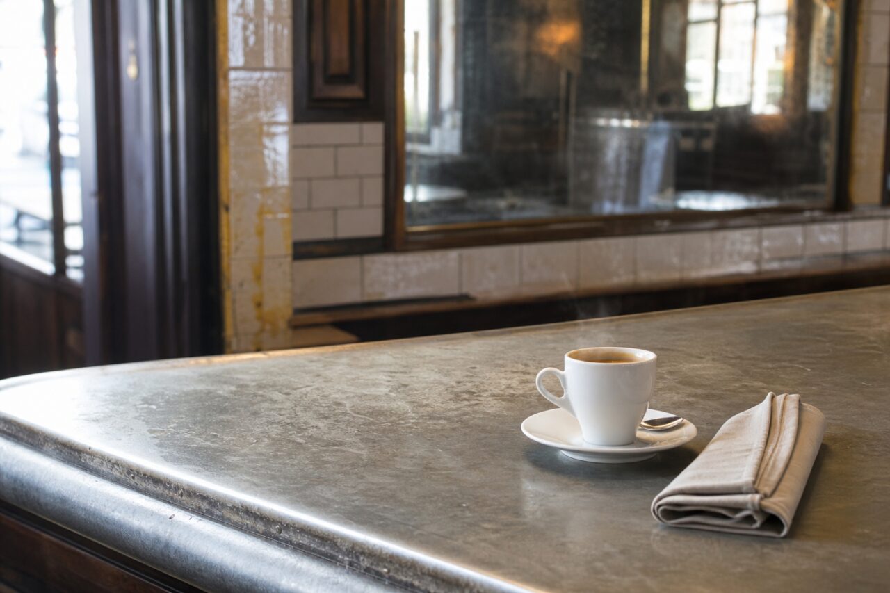 Mostrador de zinc patinado con taza de café y servilleta doblada