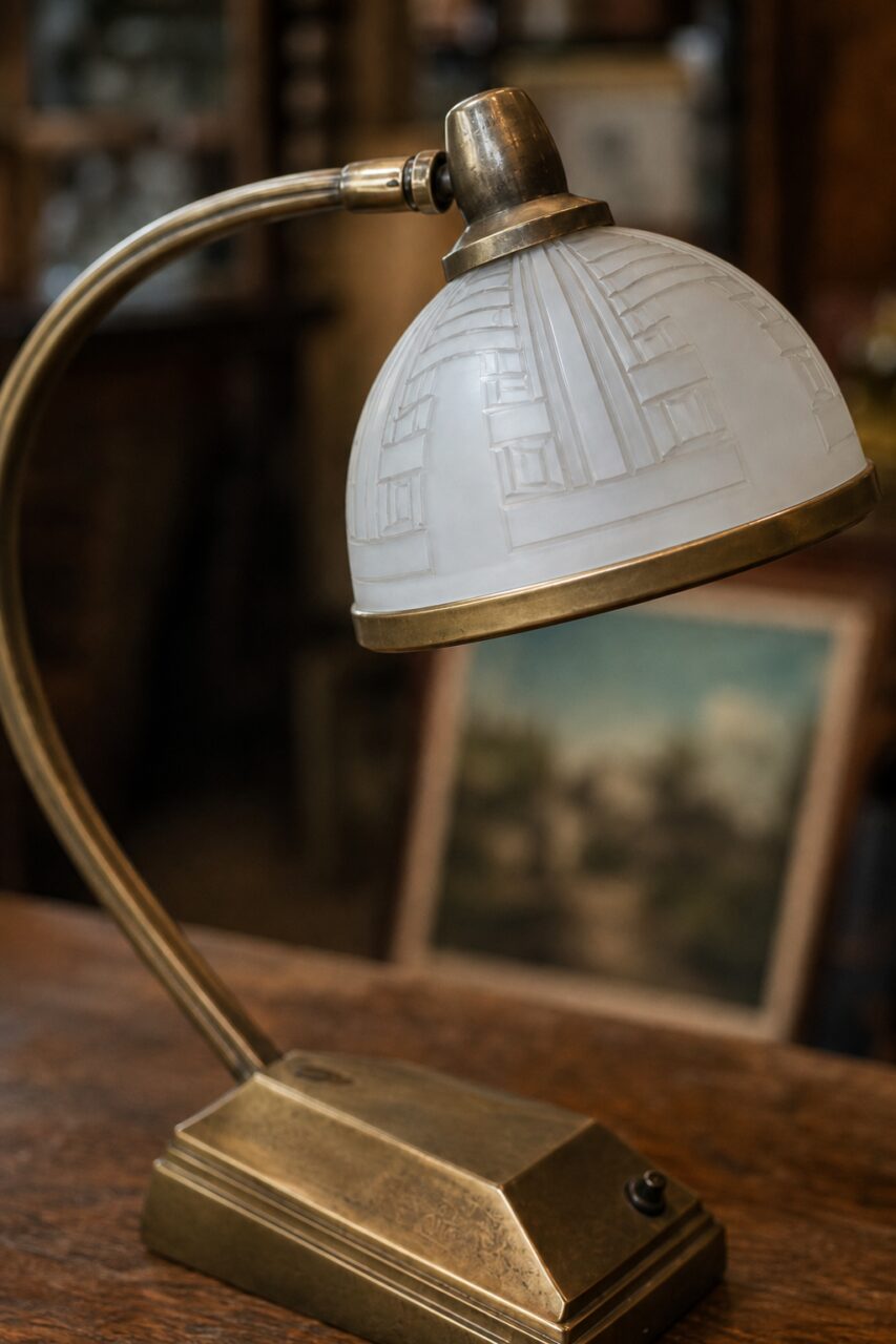Primo piano verticale del paralume in vetro satinato di una lampada Art Déco con rilievo geometrico