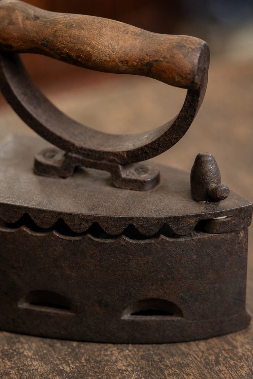 Detail von Holzgriff und gezackter Kante eines alten Bügeleisens