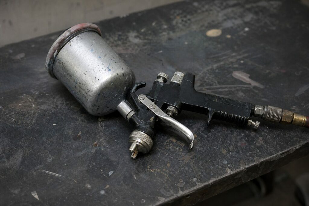 Détail rapproché d’un pistolet de pulvérisation et de ses réglages