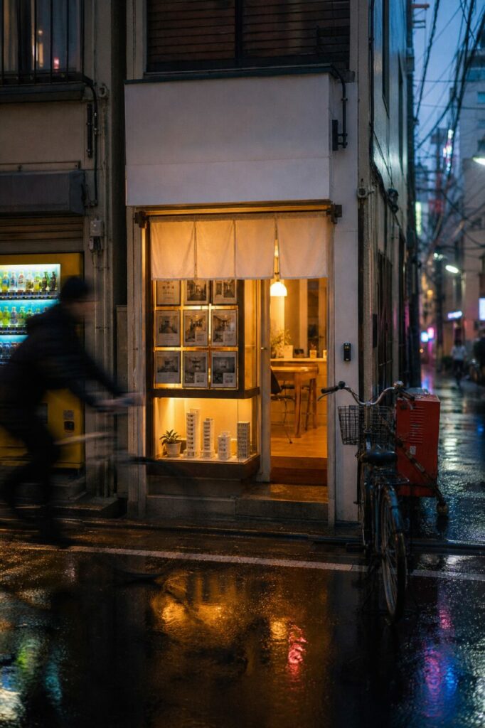 Facciata immobiliare di Tokyo con ciclista sfocato e riflessi colorati