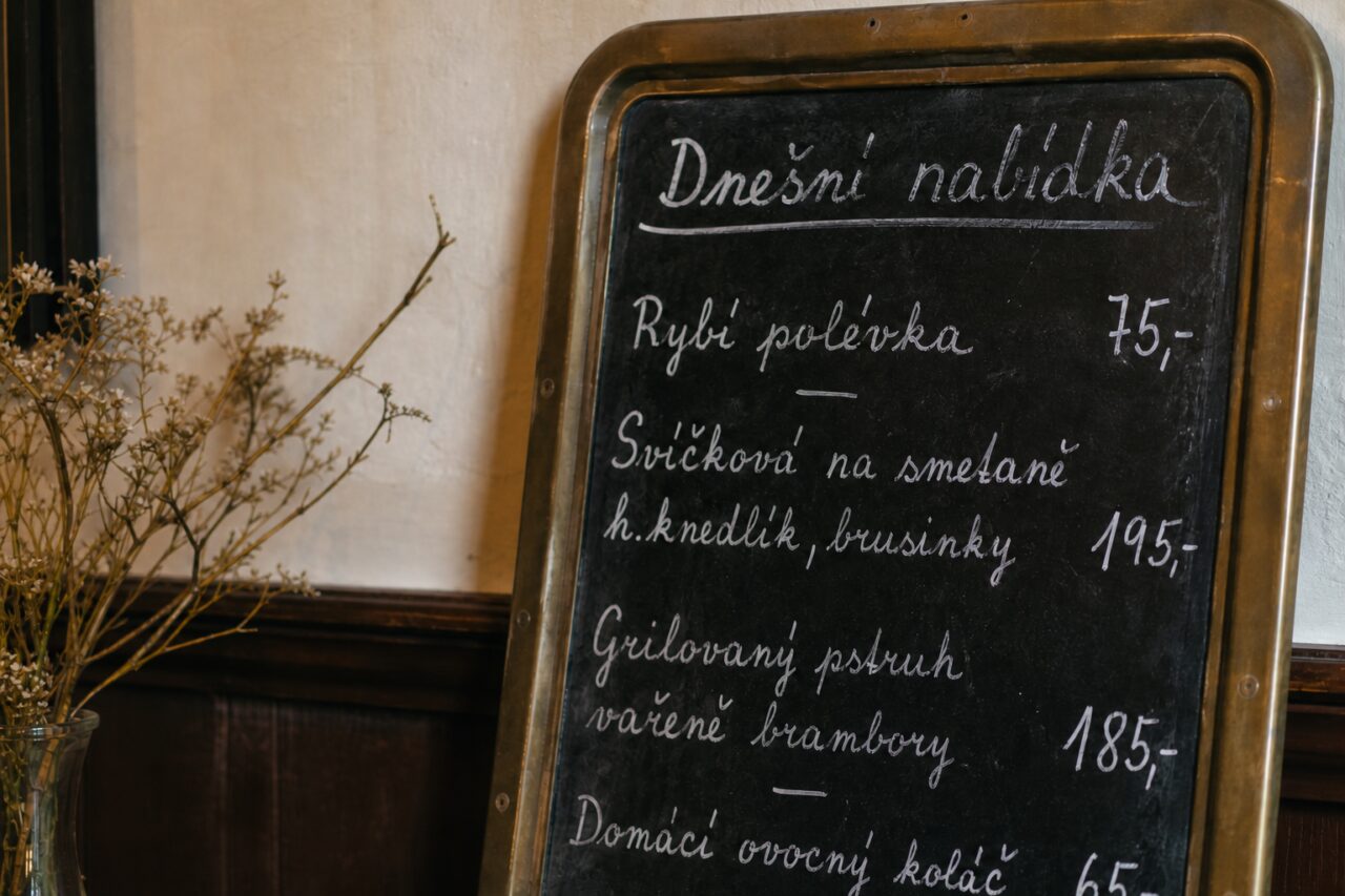 Wit handschrift en prijzen op een zwart menubord