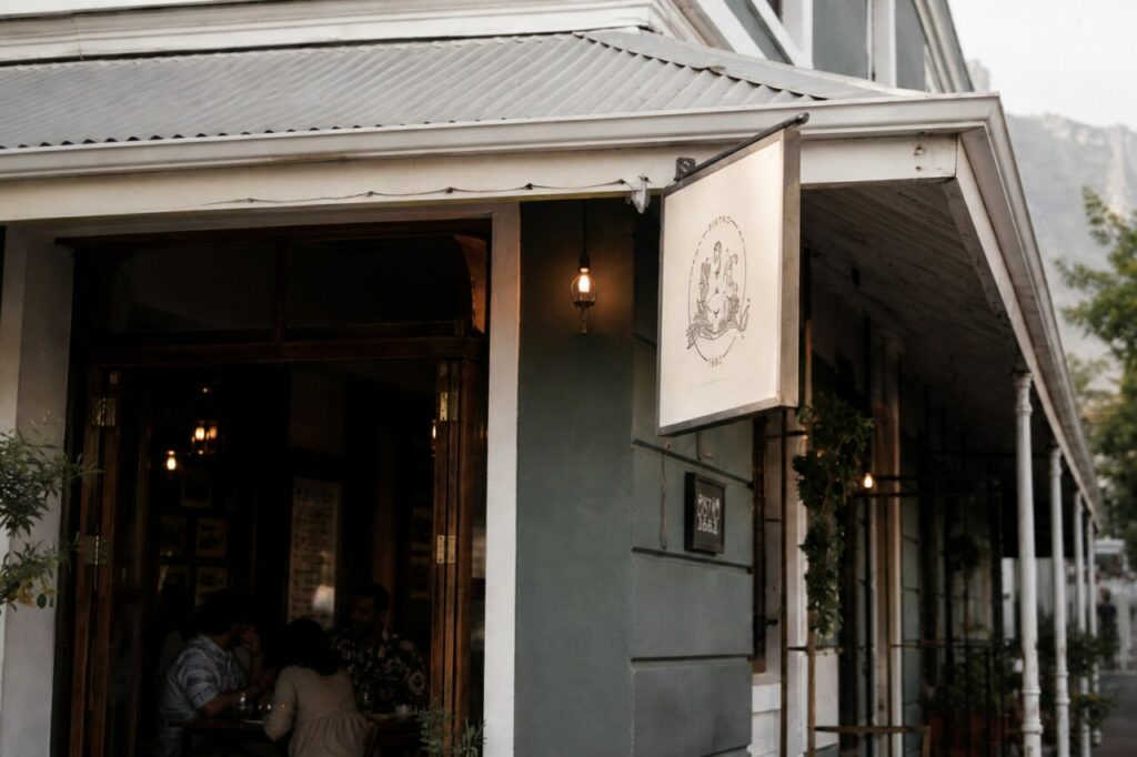 Enseigne illustrée et entrée sombre sous le toit nervuré