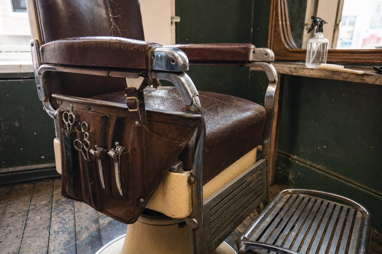 Fauteuil de barbier brun à sellerie craquelée avec outils et miroir