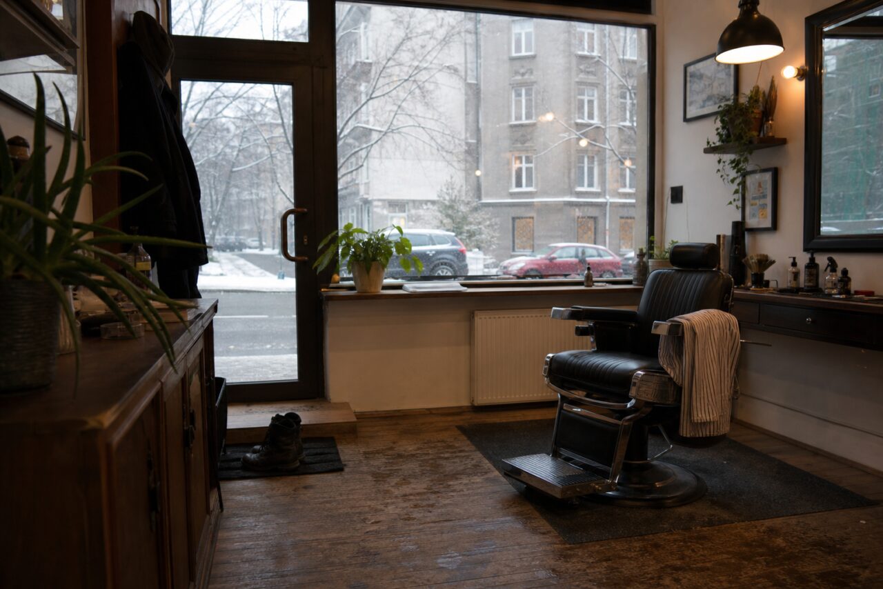 Fauteuil de barbier vide près d’une vitrine enneigée avec serviette rayée
