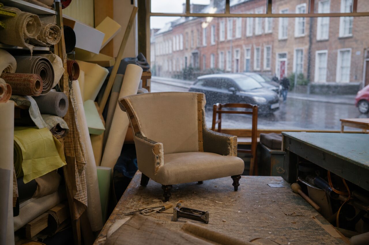 Gedeeltelijk opengewerkte fauteuil op een stoffeerderswerktafel in Dublin