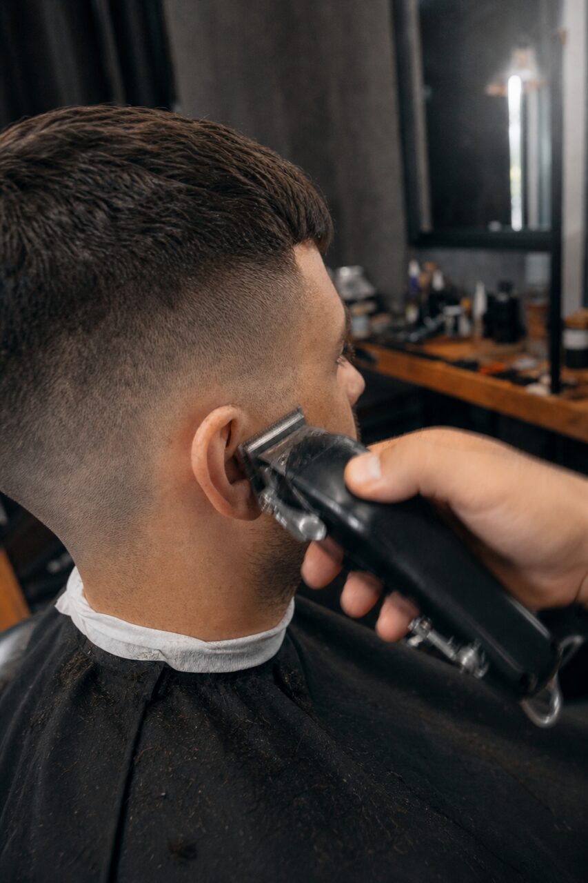 Haarschneiderbewegung hinter dem Ohr zum Verblenden des Fades