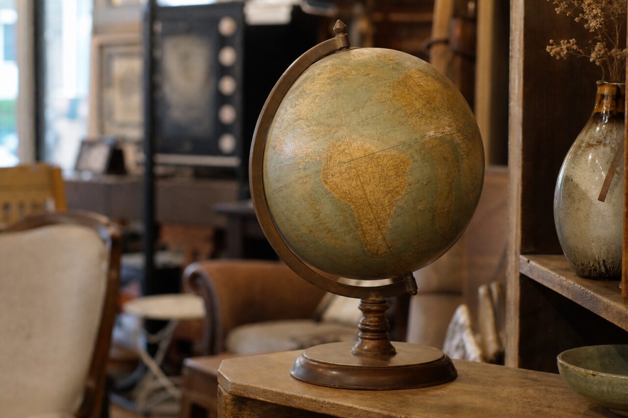Globe terrestre patiné vu de côté sur un meuble en bois de boutique