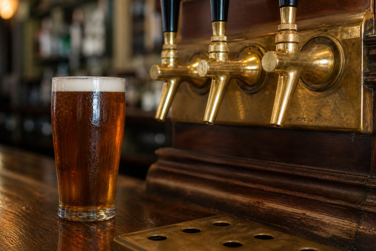 Primo piano dei beccucci in ottone sopra un bicchiere di birra