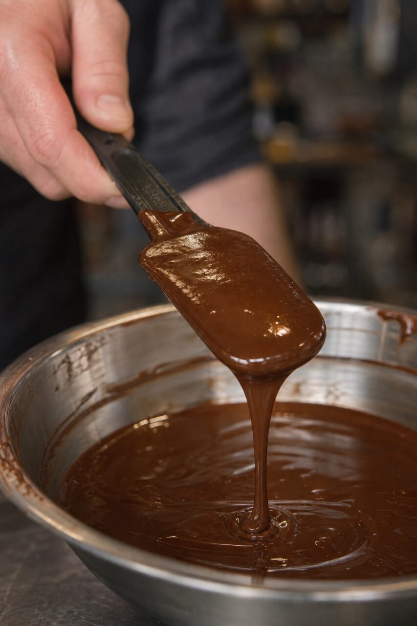Close-up of a spatula releasing a long ribbon of chocolate