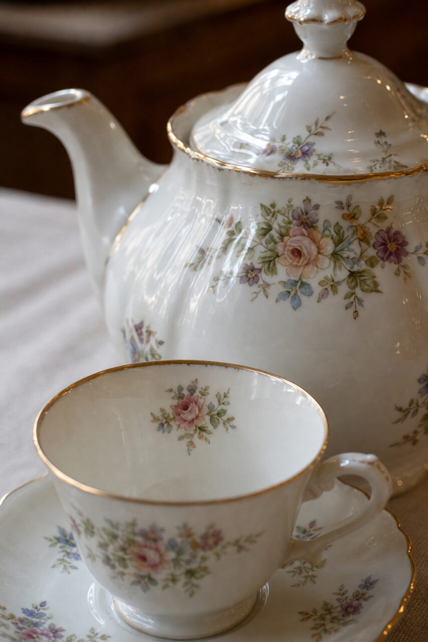 Close-up of a floral teapot and a gold-rimmed cup
