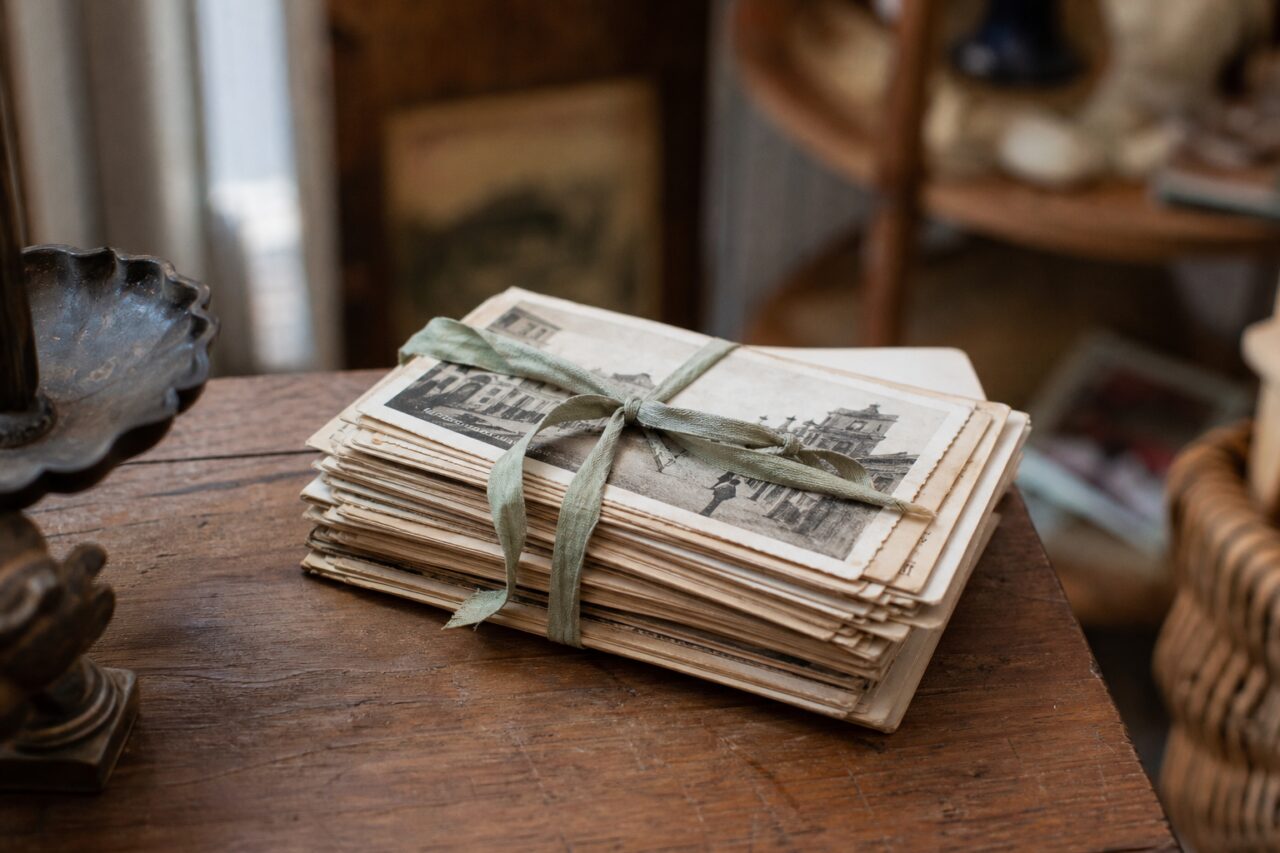 Lotto di cartoline d’epoca legato con un nastro su un tavolo in legno