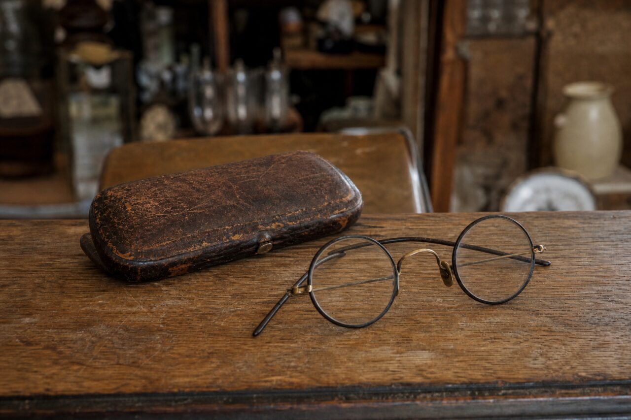 Lunettes rondes anciennes et étui brun vus de trois quarts