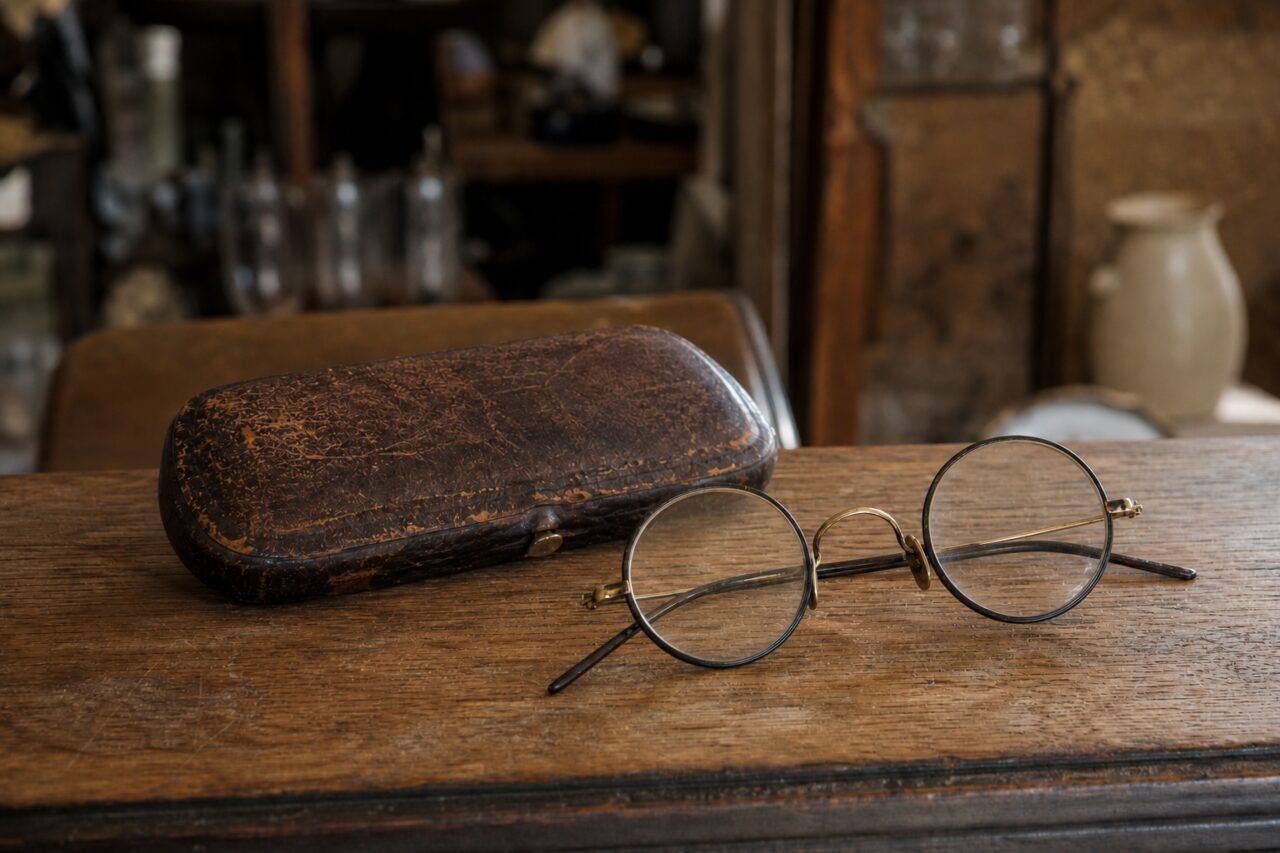 Side-lit old round glasses with their leather case
