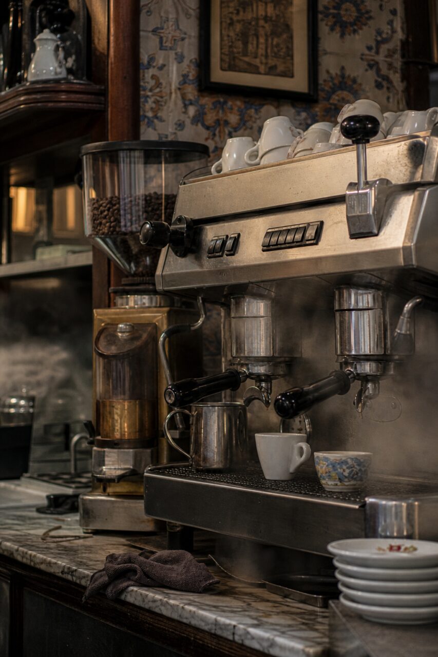 Máquina de expresso em ângulo com vapor e pires empilhados