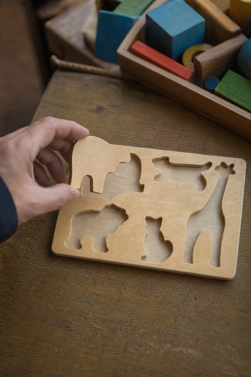 Main tenant un éléphant au-dessus d’un puzzle en bois