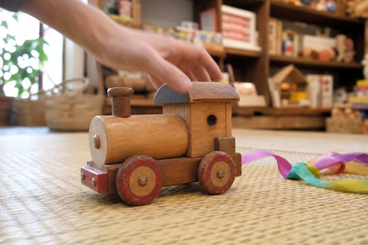 Main tendue vers le toit d’un train-jouet en bois