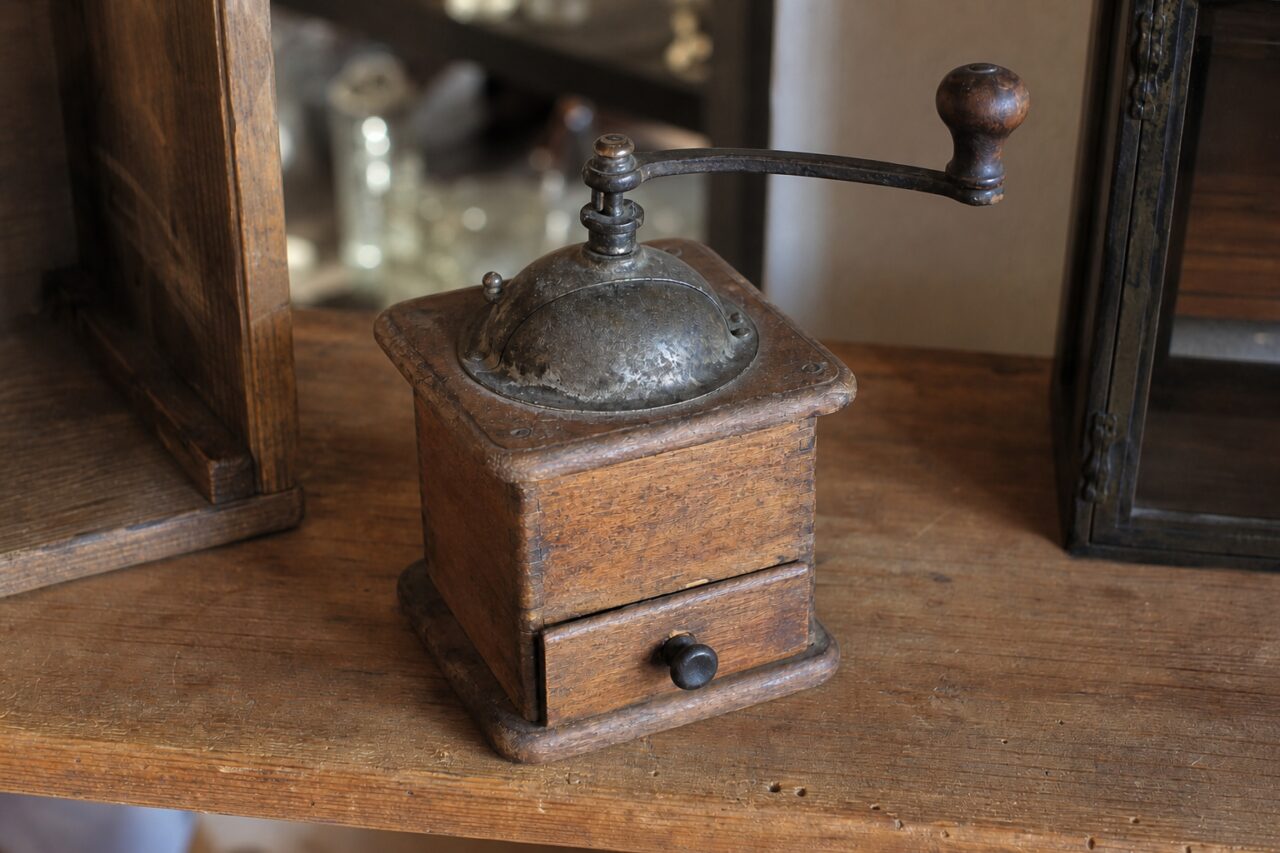 Molinillo de café de madera visto ligeramente desde arriba en un entorno antiguo
