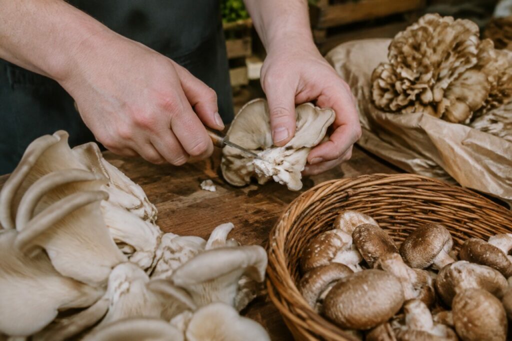 Préparation d’un pleurote sur une table en bois avec un couteau