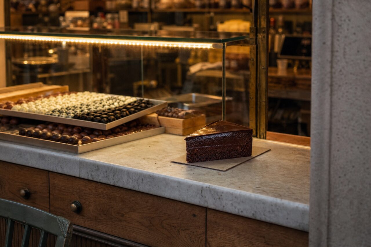 Stuk Sachertaart in een verlichte vitrine