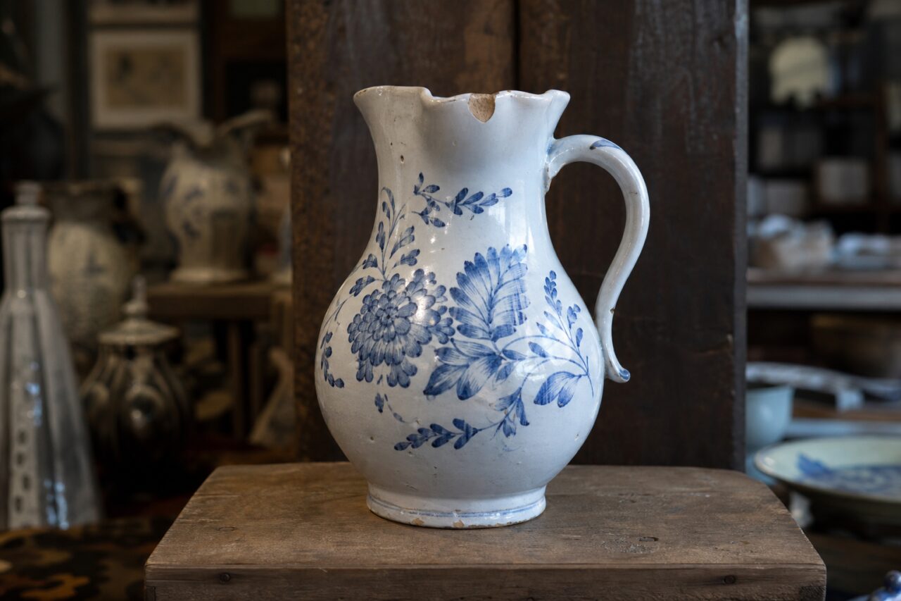 Witte keramieken kan met blauwe bloemen en beschadigde rand