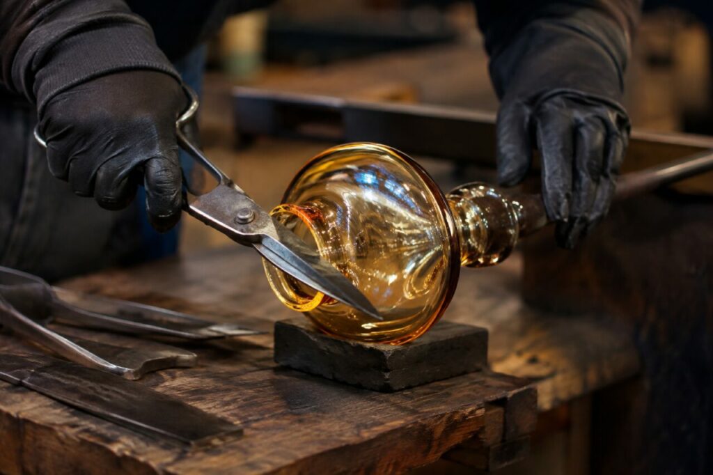 Pièce de verre en cours de façonnage près des outils de l’atelier