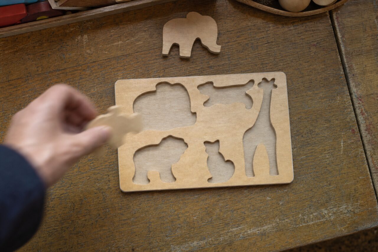 Pièce en bois en mouvement devant un puzzle d’animaux