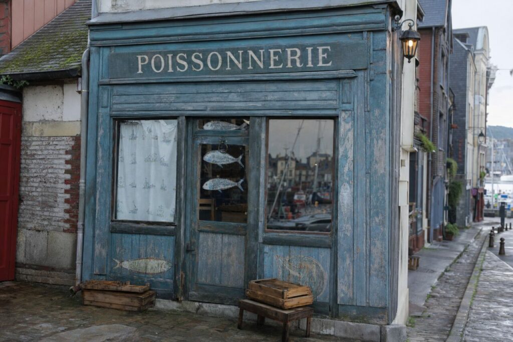 Poissonnerie ancienne à Honfleur, devanture bleue patinée et caisses en bois face au port