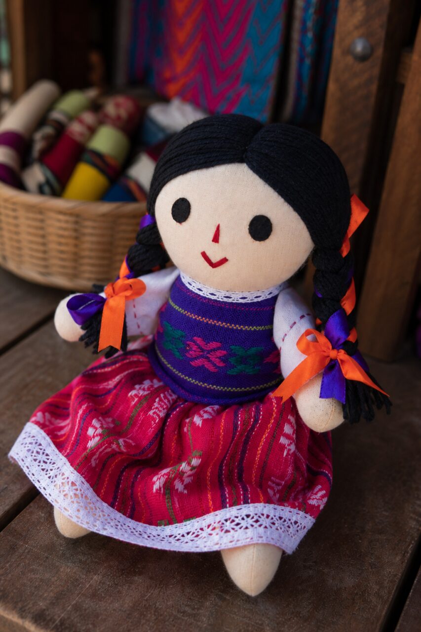 Muñeca trenzada de tres cuartos sobre una mesa de madera